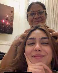 Mrunal Thakur smiling while her mother oils her hair, representing her 'rumours are free PR' Instagram story denial.