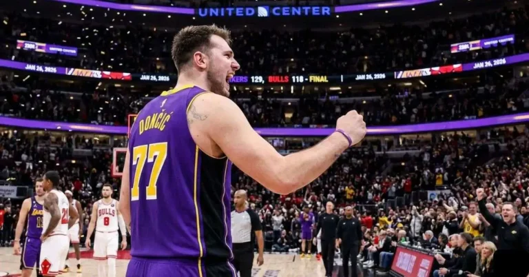 Luka Dončić #77 in a purple Lakers jersey celebrating with a fist pump during the Lakers vs Chicago Bulls game at United Center.