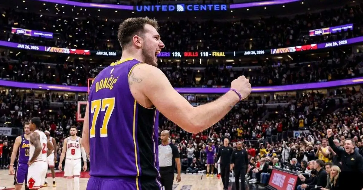 Luka Dončić #77 in a purple Lakers jersey celebrating with a fist pump during the Lakers vs Chicago Bulls game at United Center.